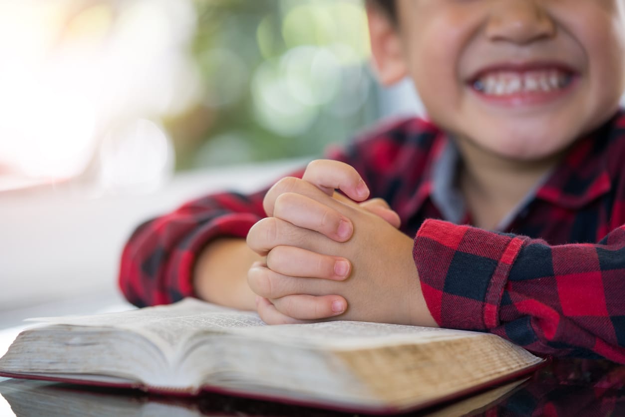 little boy reading bible religious education classes at mary our queen